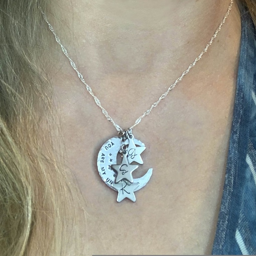 A close-up of the Moms Heavenly Moon And Stars Necklace, showing a crescent moon pendant engraved with "You are my" and three silver star charms each featuring the letters "S," "A," and "R. Read more at Stamping Cat Studio (stampingcatstudio.com).