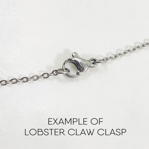 A close-up of the Dreamy Sun, Moon And Stars Necklace features an oval lobster claw clasp with a small lever in the center. Below the chain, “EXAMPLE OF LOBSTER CLAW CLASP” is written on a white background. Read more at Stamping Cat Studio (stampingcatstudio.com).