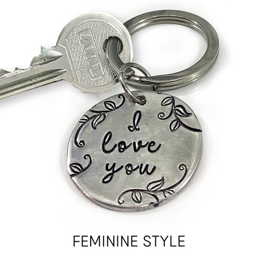 The My Love key ring feminine words is displayed: a silver key and round metal key ring engraved with "I love you" plus vine and leaf designs. The phrase "FEMININE STYLE" appears below on a white background. Read more at Stamping Cat Studio (stampingcatstudio.com).