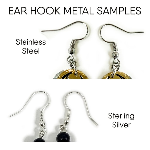 The image displays close-up comparisons of two pairs from "Hooks stainless and sterling": the top pair, labeled "Stainless Steel," with a gold-and-silver pattern; the lower, labeled "Sterling Silver," features a black bead. Read more at Stamping Cat Studio (stampingcatstudio.com).