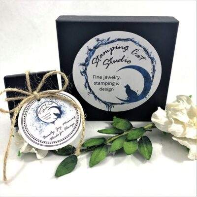 A black box with a circular “Stamping Cat Studio” logo and the text “Fine jewelry, stamping & design” sits beside a twine-tied box. In front are the Rich Lapis Lazuli, Sterling Oval Necklace and Earrings. Read more at Stamping Cat Studio (stampingcatstudio.com).